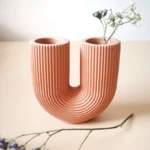 About this product Beautiful candlestick made from Jesmonite AC100. Can be used for candles (by placing seeds in the base for more grip) or as a mini vase for dried flowers as a decoration. It has a very special and beautiful shape, it blends in spaces with minimalist decoration or in the Nordic style. Dress up any room, from the living room, any bookcase or the hall of the house. It is available in 6 colors - Baby blue - Powdered pink - Moss green - Brick Red - Broken White - Terracotta brown. Due to the nature of its composition, it is possible that the candlestick has small imperfections or bubbles on its surface (something common in this type of piece) is what makes each piece unique and different. The color pattern may also vary slightly from one to the other. Each piece is created, sanded and sealed by hand with anti-moisture sealant.