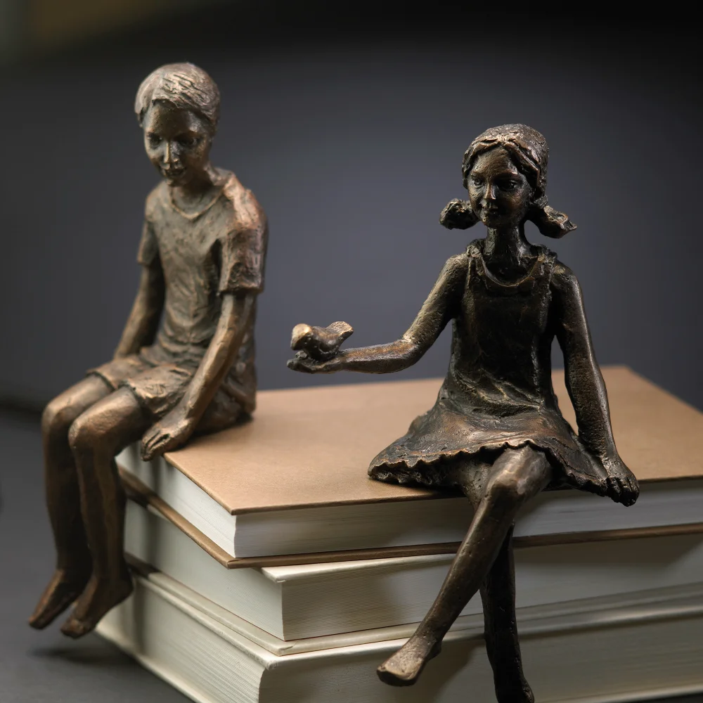 Introduce an element of whimsy to a home office bookshelf with this delightful boy shelf figure. Artfully crafted in iron, the boy rests in a sitting position on any shelf, and features a rich oiled bronze finish to complement traditional or contemporary decor. Dimensions: L 3.50 X W 3.50 X H 8.50 Weight: 2 lbs. Finish: Oiled Bronze Materials: Iron